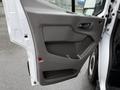 The interior door panel of a 2022 Ford Transit featuring a smooth surface and a door handle