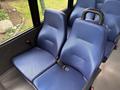 Two blue padded seats with seatbelts designed for passenger safety inside a vehicle