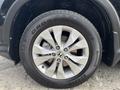 A close-up of a silver alloy wheel from a 2014 Honda CR-V featuring a black tire with the brand name and model visible