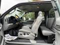 A 2006 Ford F-450 SD interior showing the driver's side with a gray bench seat and dashboard featuring controls and dials