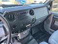 Interior view of a 2011 Ford F-550 dashboard featuring a radio control panel and a console with buttons and levers