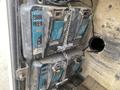 A close-up view of two stacked Makita battery packs showing various indicator lights and dirt on the surface