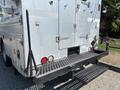 A metallic platform at the rear of a 2008 Workhorse W62 vehicle featuring a textured surface and a foldable step for easy access