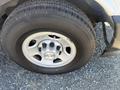 A close-up of a silver wheel and tire from a 2017 Chevrolet Express showcasing five lug nuts on a steel rim with a Chevrolet logo in the center