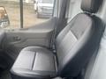 A black leather driver's seat inside a 2024 Ford Transit with ergonomic design and visible controls on the side