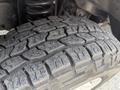 A close-up of a worn tire tread from a 2008 Ford Econoline showing deep grooves and uneven wear on the rubber surface
