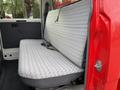 A red 2001 Toyota Dyna with a gray patterned bench seat in the cabin area