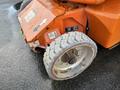 Close-up of a 2012 JLG E400AJFN electric aerial lift showing the front tire and control panel with safety labels