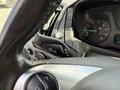 Close-up of the steering wheel and dashboard controls of a 2016 Ford Transit showing the turn signal and light controls