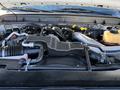 The image shows the engine compartment of a 2010 Ford F-450 featuring various engine components including hoses and an intake manifold