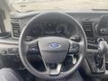 Steering wheel and dashboard of a 2024 Ford Transit displaying controls gauges and a digital display