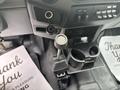 Interior view of a 2014 Ford F-550 showing the gear shift lever and cup holder with controls on the dashboard