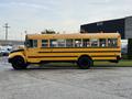 A yellow 2013 International 4300 school bus parked with multiple windows displaying notices and a roof-mounted ventilation system