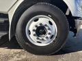 A close-up view of a tire mounted on a 2005 Freightliner M2 106 featuring a silver rim and black tread with visible lug nuts