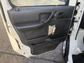 The open door of a 2008 Suzuki Carry showing the interior door panel with a handle and a circular armrest