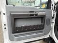 Interior door panel of a 2015 Ford F-450 featuring a gray and black design with a handle and storage compartment