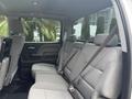 Interior view of the backseat of a 2016 GMC Sierra 1500 featuring gray upholstery and seatbelts with a spacious layout