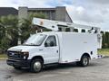 A 2017 Ford Econoline commercial vehicle with a white exterior and a raised aerial lift on top for utility work