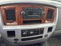 Dashboard of a 2006 Dodge Ram 2500 featuring wood grain accents and a stereo unit with buttons and knobs for audio and climate control