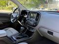 Interior view of a 2018 GMC Canyon showing the dashboard center console and gear shift with a touchscreen display and key fob hanging from the rearview mirror