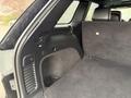 Interior view of a 2019 Jeep Grand Cherokee with a large black cargo area and foldable rear seats showing a plush carpeted floor