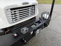A 2015 Freightliner M2 with a prominent grille and a mounted winch on a sturdy front bumper featuring an attached light and various equipment