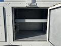 An empty cargo compartment of a 2005 Freightliner M2 106 with a single shelf and circular cutouts on the sides