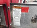 A close-up of a metal panel showing warning labels and instructions on a 2006 E-One Typhoon fire truck cab including a caution about checking the front jumpline before tilting the cab