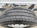 A close-up of a tire from a 2023 RAM Promaster 3500 showcasing its tread pattern and wet surface