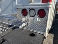 A rear view of a 2008 International 4400 truck showing red tail lights a metal checker plate surface and latching mechanisms on the back end