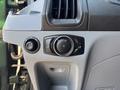 Control panel in a 2016 Ford Transit 150 featuring knob for headlights and a dial for interior lighting settings