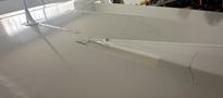Close-up view of a gray wing section of a 1986 Sorrell Hiperbipe SNS-7 aircraft featuring a repair patch made of tape and a small crack in the surface