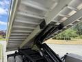 A 2020 Chevrolet Silverado truck with its dump bed raised, showcasing the hydraulic lift mechanism and the bed's interior structure
