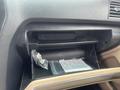 A partially open glove compartment in a 2016 Ford Explorer containing plastic bags and a rectangular item inside