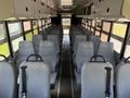 Interior of a 2009 International 3000 CE school bus featuring rows of gray seats with safety straps and an empty aisle down the middle