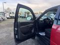 A 2011 Chevrolet Avalanche with the driver's side door open displaying the interior and dashboard features