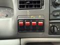 A dashboard panel of a 2000 Ford F-450 featuring four red toggle switches with labels near them