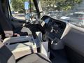 Interior of a 2006 Freightliner M2 106 featuring a driver's seat dashboard gear shifter and center console with various controls and storage compartments
