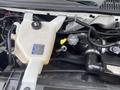 The engine compartment of a 2020 Chevrolet Express showing the coolant reservoir and various engine components including hoses and caps