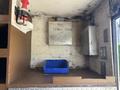 A metal compartment labeled 400 series is mounted on a wall inside a vehicle with a blue storage bin on a wooden shelf and a fire extinguisher next to it