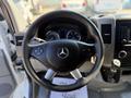 A steering wheel of a 2017 Mercedes-Benz Sprinter with controls on the left and right sides featuring the Mercedes logo in the center