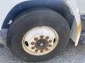 A close-up of the tire on a 1997 Freightliner FL70 showing the rim and the Michelin brand lettering with visible wear and rust on the wheel