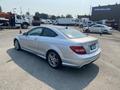 A 2013 Mercedes-Benz C-Class coupe in silver parked at a lot showing its sleek design and sporty profile