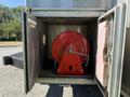 A red hose reel with a metal frame positioned inside a grey storage compartment of a 2009 Morgan Olson Workhorse W62