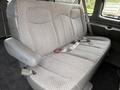 A grey upholstered bench seat from a 2004 Chevrolet Express with seatbelts and a textured pattern