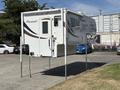A 2018 Westland Travelaire camper mounted on a set of support legs with a door and window visible on the side