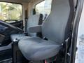 Interior of a 2015 Hino 358 showing the driver's seat and a passenger seat both upholstered in gray fabric with armrests