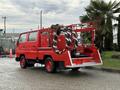 A red 2001 Toyota Dyna truck with a large hose reel and equipment mounted on the back, designed for utility or firefighting purposes