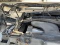 A 2012 Ford Econoline engine compartment showing various components including the engine block wiring and battery connections
