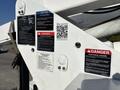A 2006 Freightliner M2 106 with various warning and safety labels attached to the body